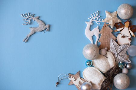 Christmas mood flat lay. Happy New Year flat lay on the paper. Christmas tree ornament set on blue paper. Mittens, stars, deer. tree. Vintage retro Christmas ornaments.の写真素材