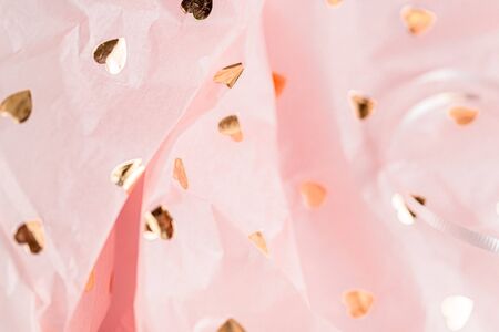 Pastel pink gift paper with golden hearts in white present box. Gift wrapping for special occasion....