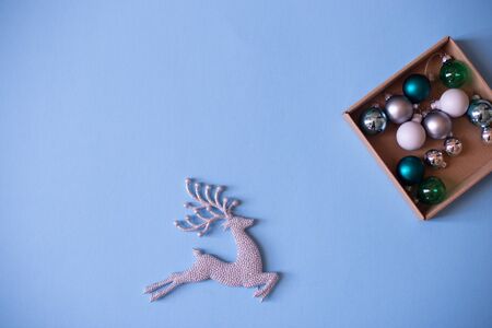 Christmas mood flat lay. Happy New Year flat lay on the paper. Sparkling silver deer ornaments on blue paper.の写真素材