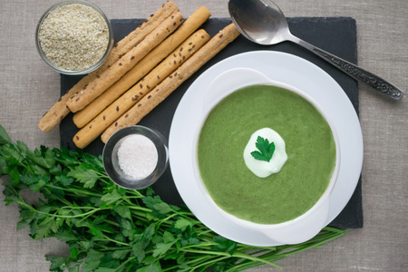 Spinach cream soup with parsley and sour creamの写真素材