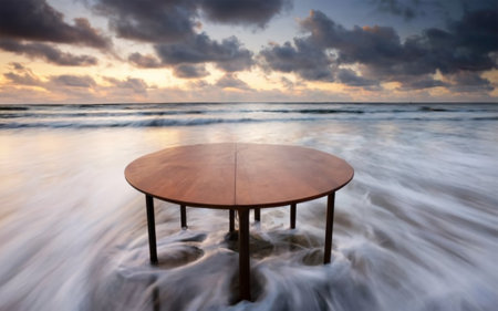 Wooden table and wave on the beach in the evening at sunsetの素材