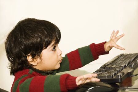 A cute little child working on his PC の写真素材