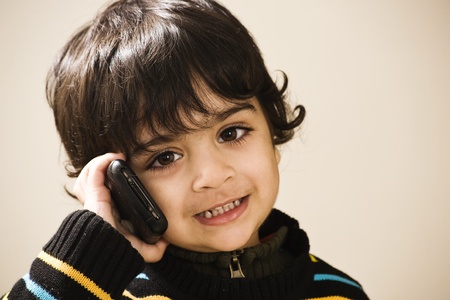 adorable little boy talking over the phone の写真素材