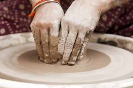 female potter s hands shaping up the terracotta clay pot on wheal  の写真素材