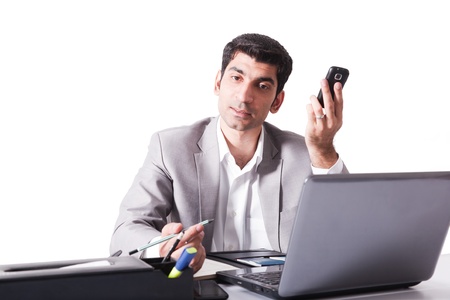 young businessman working on laptop while talking over the cell phone, man multitaskingの写真素材