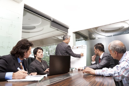 young businessman giving presentation to a group of multi racial group of colleagues, a group of diversed businessmen.の写真素材