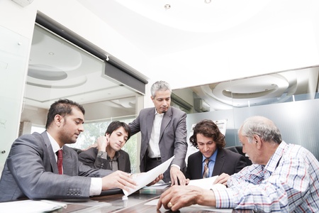 young businessman giving presentation to a group of multi racial group of colleagues, a group of diversed businessmen.の写真素材