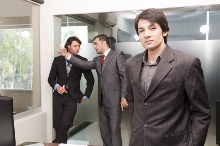 portrait of a young asian businessman with his colleagues in backgroundの写真素材