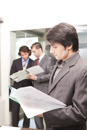 portrait of a young asian businessman with his colleagues in backgroundの写真素材