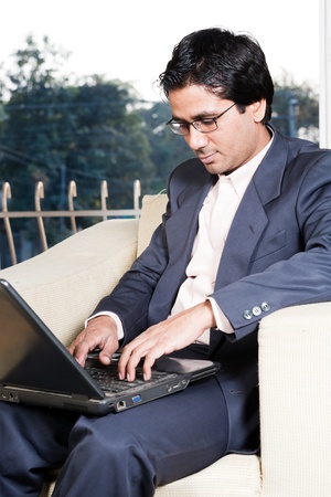 thoughtful Indian businessman working on laptop, businessman lost in deep thoughtsの写真素材