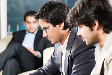 confident indian businessman with his colleagues in the backgroundの写真素材