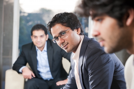 confident indian businessman with his colleagues in the backgroundの写真素材