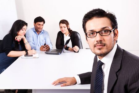 close up of a confident businessman with his colleagues in the backgroundの写真素材