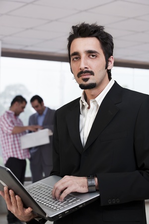 young businessman with colleagues in backgroundの写真素材