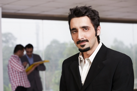 young businessman with colleagues in backgroundの写真素材