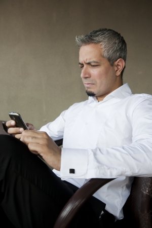 Portrait of a young businessman using his mobile or cell phoneの写真素材