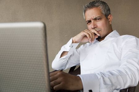portrait of a handsome businessman with grey hair working on the laptop, Indian muslim businessman working の写真素材