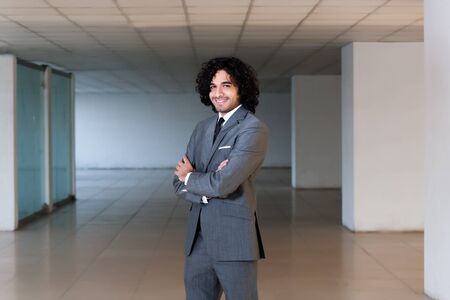 mixed race businessman standing in the office hall, portrait of a busineeman with copy space の写真素材