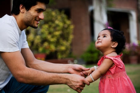 father helping his daughter to take first step of lifeの写真素材