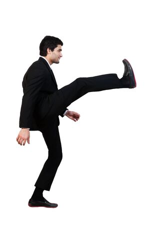 young businessman kicks in the air with aggression isolated on whiteの写真素材