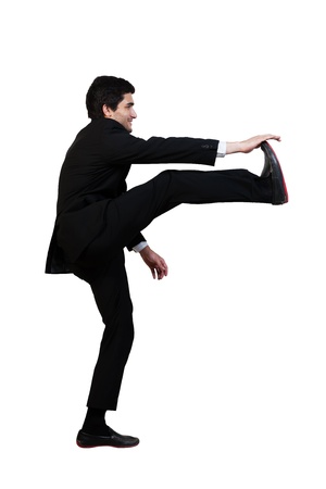 young businessman kicks in the air with aggression isolated on whiteの写真素材