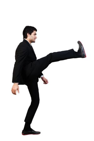 young businessman kicks in the air with aggression isolated on whiteの写真素材