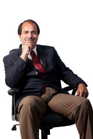 happy and confident senior businessman sitting in the office chair isolated on white backgroundの写真素材