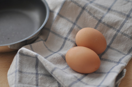 Two brown eggs over a kitchen cloth and a frying pan
の写真素材