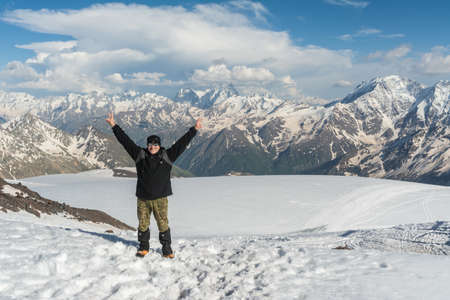 Caucasus / Russia - 02/06/2008 Group of climbers, acclimatization program in the mountains before climbing Mount Elbrus. Tourists take pictures on the background of high snowy mountain peaks.のeditorial素材