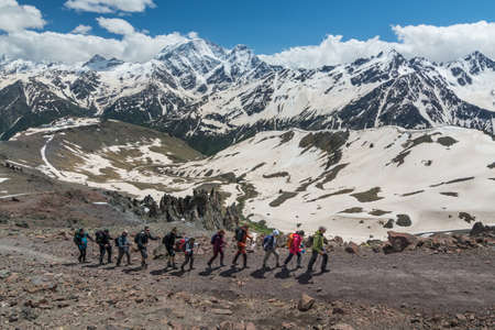 Caucasus / Russia - 02/06/2008 Group of climbers, acclimatization program in the mountains before climbing Mount Elbrus. Tourists take pictures on the background of high snowy mountain peaks.のeditorial素材