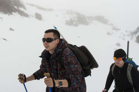 Caucasus / Russia - 02/06/2008 Group of climbers, acclimatization program in the mountains before climbing Mount Elbrus. Tourists take pictures on the background of high snowy mountain peaks.のeditorial素材