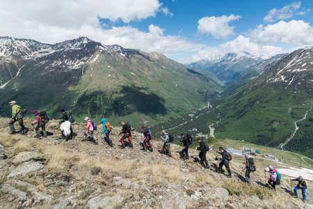 Caucasus / Russia - 02/06/2008 Group of climbers, acclimatization program in the mountains before climbing Mount Elbrus. Tourists take pictures on the background of high snowy mountain peaks.のeditorial素材