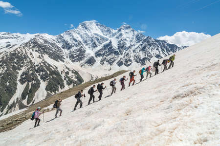 Caucasus / Russia - 02/06/2008 Group of climbers, acclimatization program in the mountains before climbing Mount Elbrus. Tourists take pictures on the background of high snowy mountain peaks.のeditorial素材
