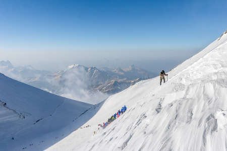 Caucasus / Russia - 07/31/2018 Group of climbers climbing mountain peaks.