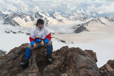 Caucasus / Russia - 22/06/2008 Group of climbers, acclimatization program in the mountains before climbing Mount Elbrus. Tourists take pictures on the background of high snowy mountain peaks.のeditorial素材