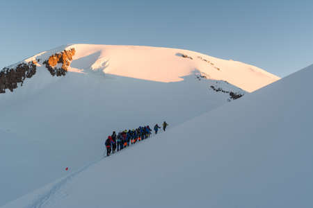 Caucasus / Russia - 22/06/2008 Group of climbers, acclimatization program in the mountains before climbing Mount Elbrus. Tourists take pictures on the background of high snowy mountain peaks.のeditorial素材