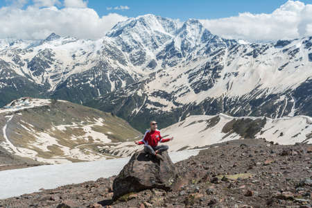 Caucasus / Russia - 02/06/2008 Group of climbers, acclimatization program in the mountains before climbing Mount Elbrus. Tourists take pictures on the background of high snowy mountain peaks.のeditorial素材