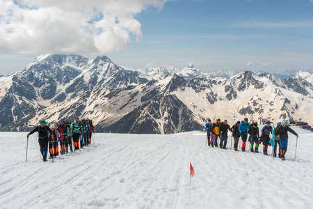 Caucasus / Russia - 02/06/2008 Group of climbers, acclimatization program in the mountains before climbing Mount Elbrus. Tourists take pictures on the background of high snowy mountain peaks.のeditorial素材