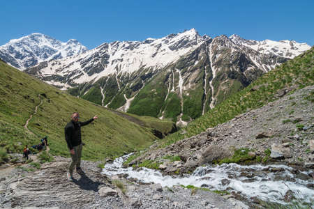 Caucasus / Russia - 02/06/2008 Group of climbers, acclimatization program in the mountains before climbing Mount Elbrus. Tourists take pictures on the background of high snowy mountain peaks.のeditorial素材