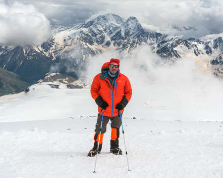 Caucasus / Russia - 02/06/2008 Group of climbers, acclimatization program in the mountains before climbing Mount Elbrus. Tourists take pictures on the background of high snowy mountain peaks.のeditorial素材