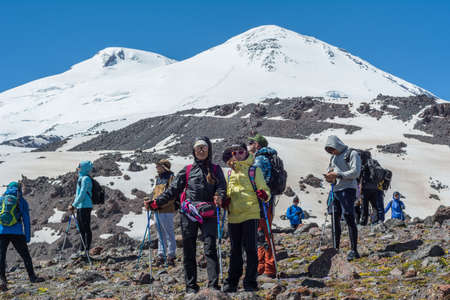 Caucasus / Russia - 02/06/2008 Group of climbers, acclimatization program in the mountains before climbing Mount Elbrus. Tourists take pictures on the background of high snowy mountain peaks.のeditorial素材