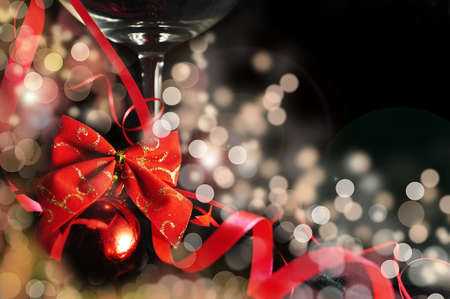 christmas background with red ribbon, ball and glass for wineの写真素材
