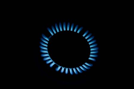 blue flames of gas stove in the darkの写真素材