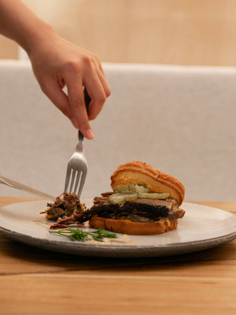 Beef burger on a plate with a fork on a wooden table
