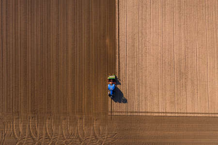 Different shades of brown appear on a field that is plowed with a tractorの写真素材