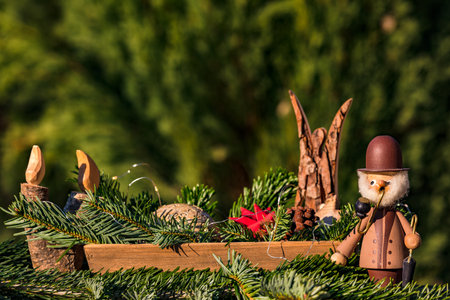 A bowl with decorative elements such as a smoker, an angel and a wooden candle for Christmasの写真素材