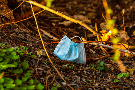 A mouth and nose mask lies soiled in a German forestの写真素材