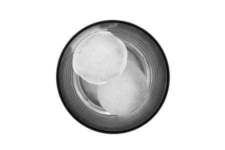 Top view of a clear glass with two round ice cubes isolated on a white backgroundの写真素材