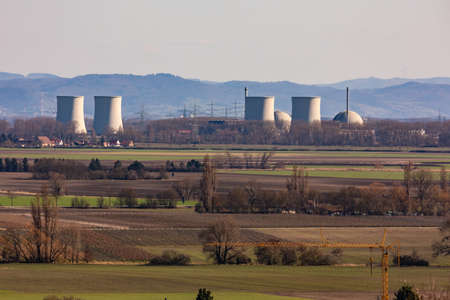 View of a nuclear power plant with houses and vineyards in the foreground