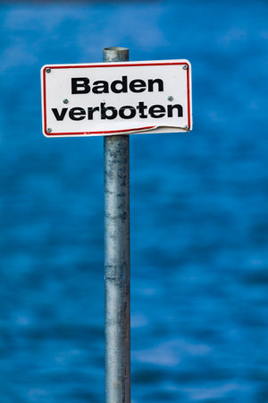 German sign with a red border baden verboten - no swimming - in front of a body of waterの写真素材